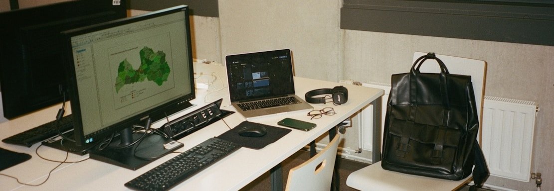 Modern office desk with a laptop showing a digital map of global logistics routes.