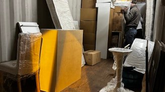 A professional moving crew carefully loading furniture into a container for international shipping.