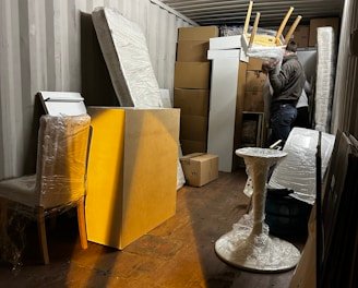 A professional mover carefully packing a client's belongings into a sturdy box.