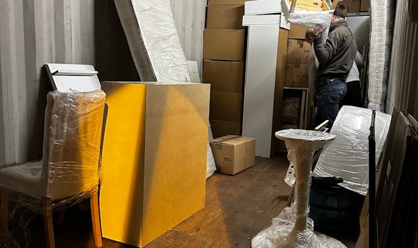 A professional mover carefully packing a client's belongings into a sturdy box.